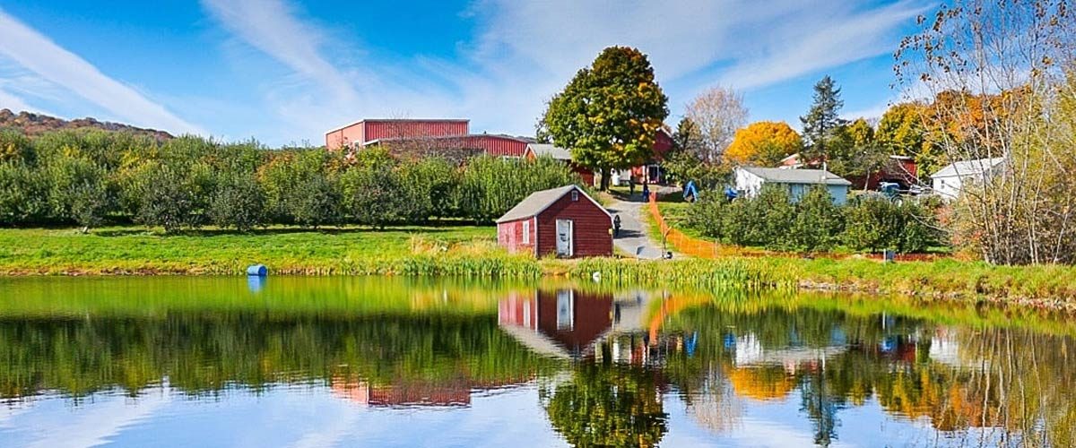 Landscape Lake with blue skies and a red barn