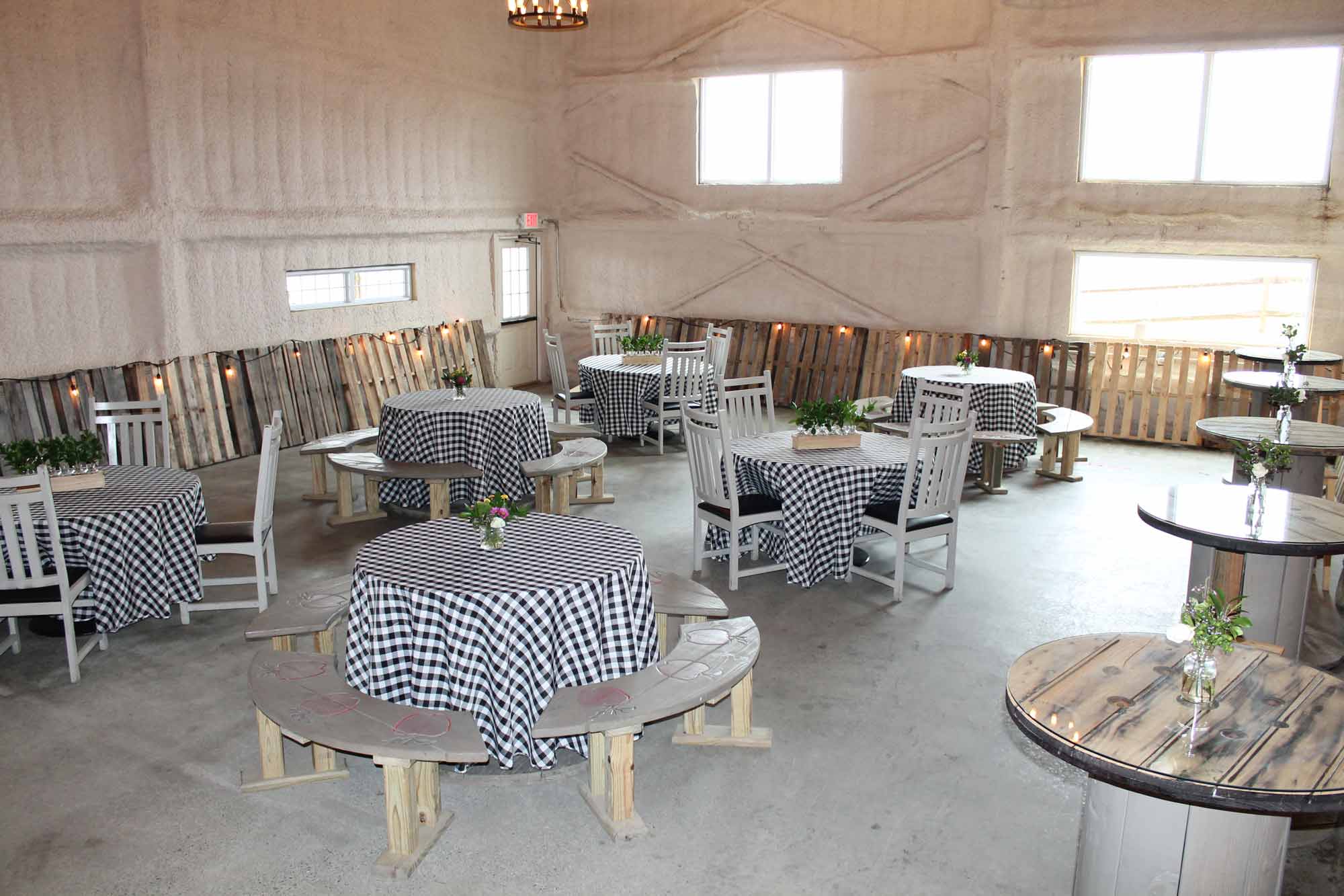 The room is staged with black and white checkered tablecloths covering the tables with bright light coming through the windows.