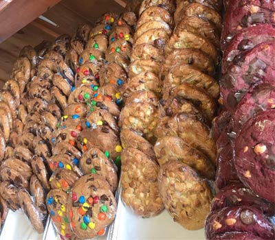 Cookies featuring flavors like chocolate chip M&M's and Macadamia nut.