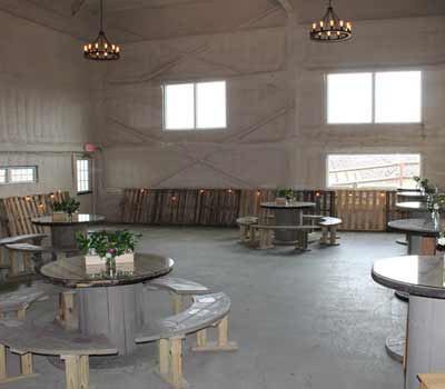 A small thumbnail of a while walled venue with wooden tables