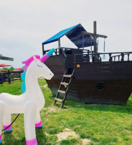 A large wooden play ship with an inflatable unicorn