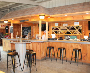 A tasting Room with woodwork and black bar stools