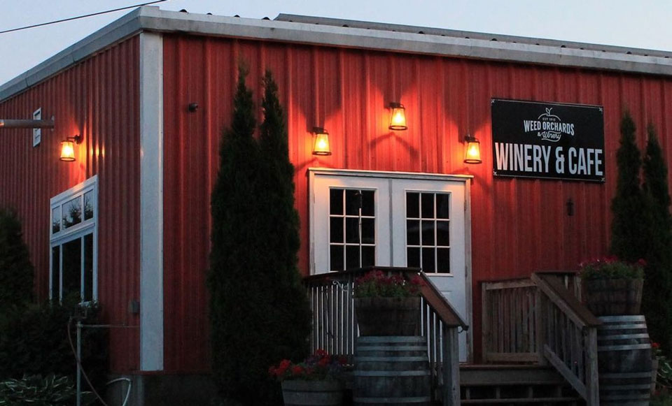 the front building of the winery at dusk with the spotlights on