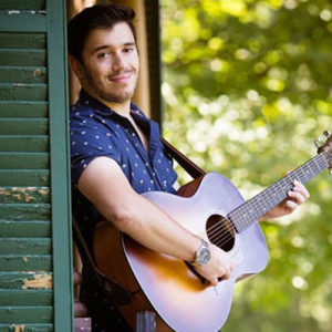 Sam Miller posting with his guitar