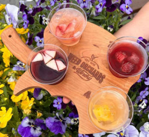 A wood palette shaped like an apple with 4 drink samples